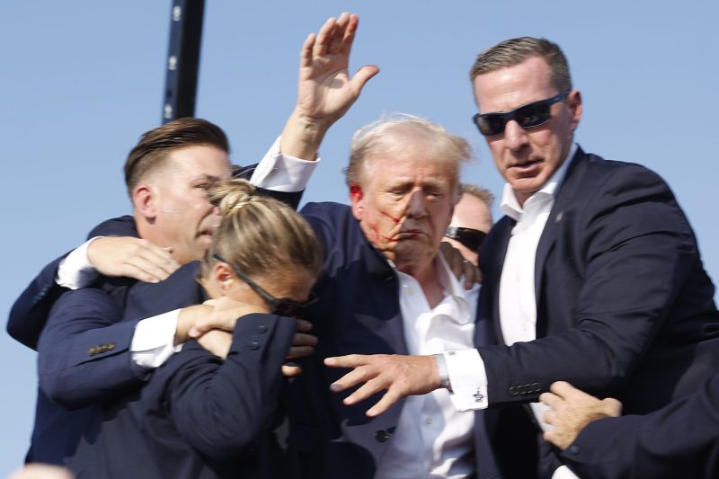 Foto: Kandidat presiden dari Partai Republik dan mantan Presiden AS Donald Trump tampak berlumuran darah dibantu oleh petugas keamanan setelah tertembak saat kampanye di Butler Farm Show di Butler, Pennsylvania, AS, 13 Juli 2024. 