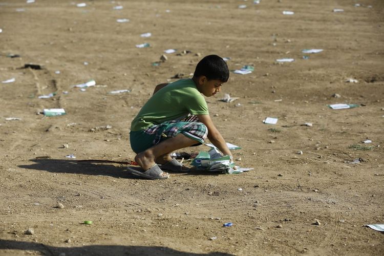 Kondisi perang Israel-Hamas terkini. Seorang anak laki-laki Palestina mengumpulkan selebaran yang dijatuhkan militer Israel.